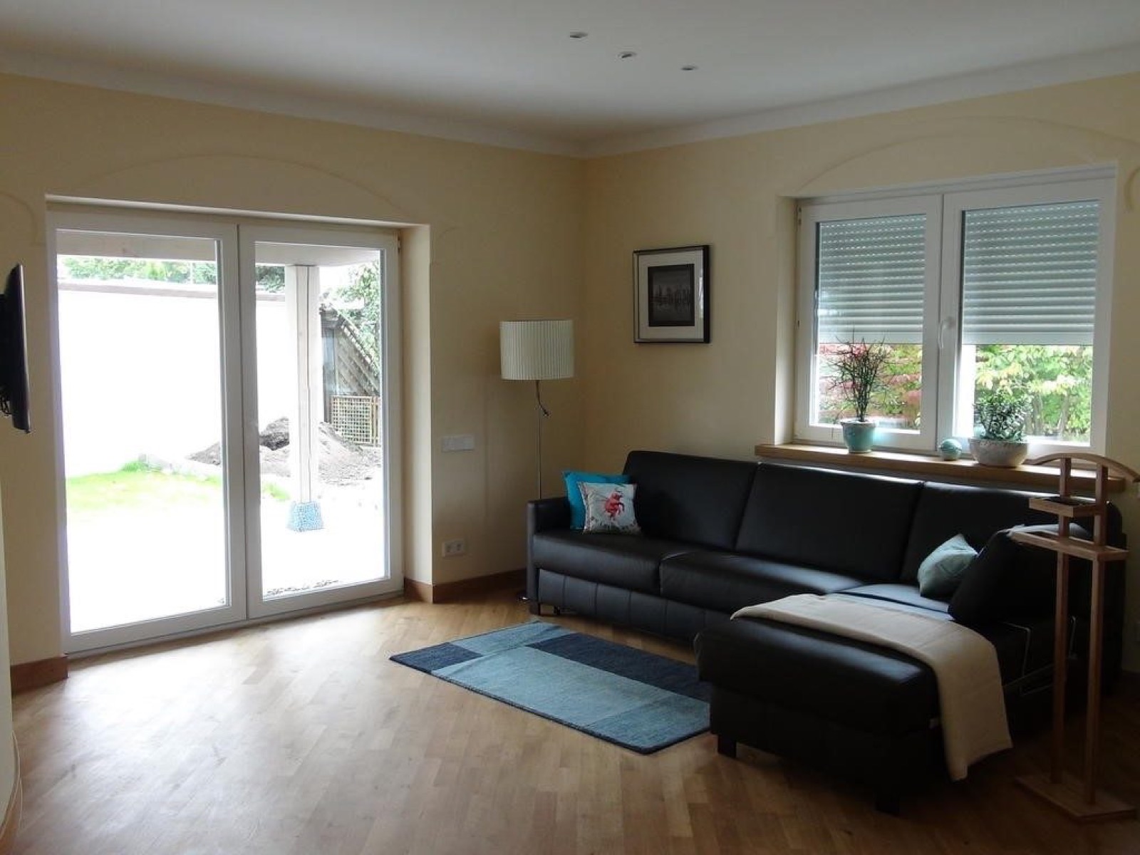 Wohnbereich der Ferienwohnung Aqua mit Sofa und Terrassentür