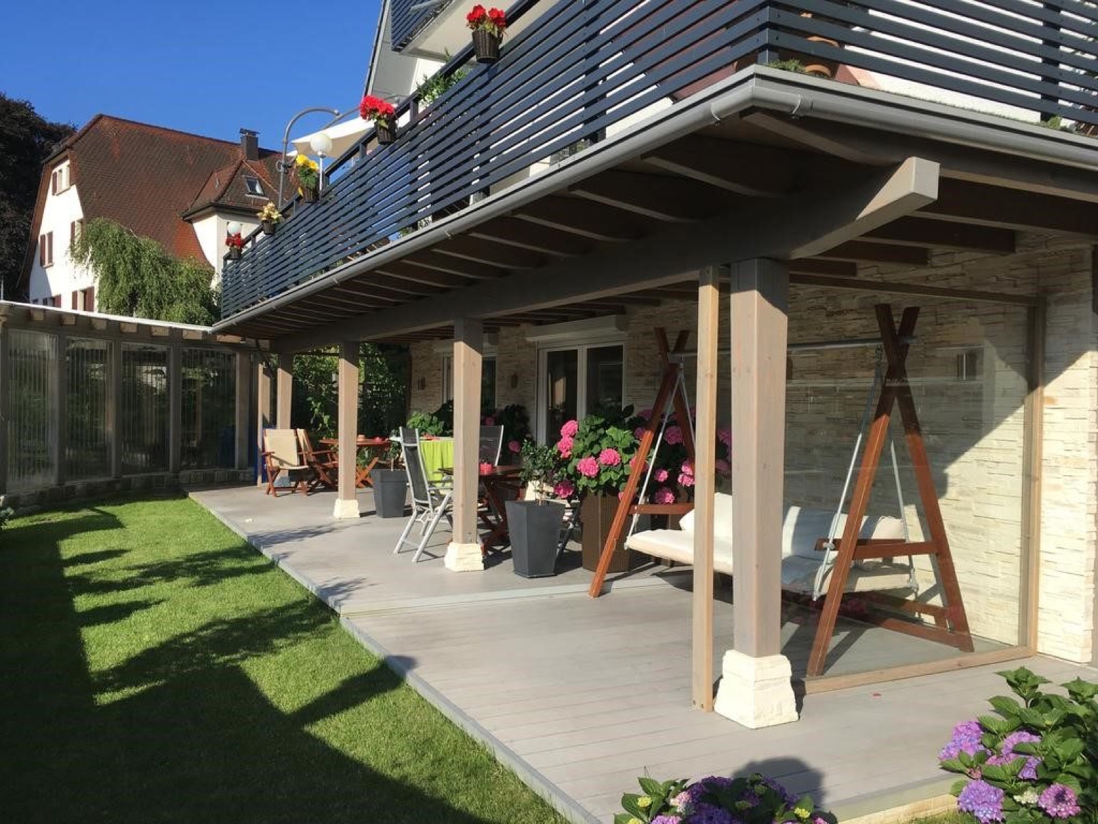 Überdachte Terrasse mit Garten an der Wohnung Terra